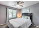 A bedroom features a gray wall color, carpet flooring, curtains, a ceiling fan, and a queen-sized bed at 7435 W Trails Dr, Glendale, AZ 85308
