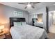 A bedroom features a gray wall color, carpet flooring, curtains, a ceiling fan, and a queen-sized bed at 7435 W Trails Dr, Glendale, AZ 85308