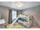 A bedroom featuring carpet flooring, a chandelier ceiling fan, a bunk bed with a slide, and curtains at 7435 W Trails Dr, Glendale, AZ 85308