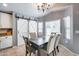 Cozy dining room features an elegant chandelier, a rustic table set, and charming barn doors at 7435 W Trails Dr, Glendale, AZ 85308