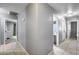 Hallway with neutral paint, tile flooring, and doors leading to various rooms, showcasing the home's layout at 7435 W Trails Dr, Glendale, AZ 85308