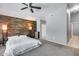 Spacious main bedroom featuring a wood accent wall, plush carpet, and a ceiling fan for comfort at 7435 W Trails Dr, Glendale, AZ 85308