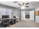 Well-lit home office with a ceiling fan, computer setup, and carpet flooring at 7435 W Trails Dr, Glendale, AZ 85308