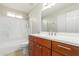 Bathroom with a wood vanity, bright lighting, and shower-tub combo at 7526 W Windrose Dr, Peoria, AZ 85381