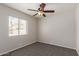 Bedroom featuring carpet, a ceiling fan, and natural light through a bright window at 7526 W Windrose Dr, Peoria, AZ 85381