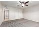 Spacious bedroom featuring plush carpeting, a ceiling fan, and a large closet at 7526 W Windrose Dr, Peoria, AZ 85381