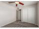 Bedroom with ceiling fan, plush carpet, neutral walls, and closet space at 7526 W Windrose Dr, Peoria, AZ 85381
