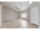Spacious living room with neutral paint, tile floors, a ceiling fan and a large window at 7526 W Windrose Dr, Peoria, AZ 85381