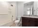 Bathroom featuring granite counters, dark wood cabinets, and bathtub with shower at 8253 W Illini St, Phoenix, AZ 85043
