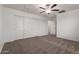 Bedroom featuring neutral carpet, ceiling fan, and large closet space at 8253 W Illini St, Phoenix, AZ 85043