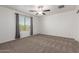 Spacious bedroom with neutral carpet, ceiling fan, and large window with views at 8253 W Illini St, Phoenix, AZ 85043