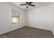Empty bedroom with carpet and ceiling fan plus a window with a neighborhood view at 8253 W Illini St, Phoenix, AZ 85043