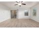 Spacious bedroom with wood-look floors, a ceiling fan, and natural light at 8253 W Illini St, Phoenix, AZ 85043
