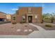 Inviting two-story home featuring a neutral stucco facade and tile roof, complemented by a gravel yard and charming entryway at 8253 W Illini St, Phoenix, AZ 85043