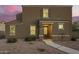 Inviting two-story home featuring a neutral stucco facade and tile roof, complemented by a gravel yard and charming entryway at 8253 W Illini St, Phoenix, AZ 85043