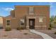 Inviting two-story home featuring a neutral stucco facade and tile roof, complemented by a gravel yard and charming entryway at 8253 W Illini St, Phoenix, AZ 85043