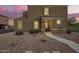 Inviting two-story home featuring a neutral stucco facade and tile roof, complemented by a gravel yard and charming entryway at 8253 W Illini St, Phoenix, AZ 85043