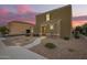 Inviting two-story home featuring a neutral stucco facade and tile roof, complemented by a gravel yard and charming entryway at 8253 W Illini St, Phoenix, AZ 85043
