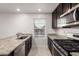 Modern kitchen featuring granite countertops, stainless steel appliances, and dark cabinets at 8253 W Illini St, Phoenix, AZ 85043
