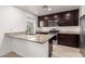 Stylish kitchen with stainless steel appliances, dark wood cabinets, and granite countertops at 8253 W Illini St, Phoenix, AZ 85043