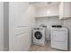 Functional laundry room with washer, dryer and ample shelving for storage at 8253 W Illini St, Phoenix, AZ 85043