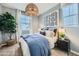 Comfortable bedroom featuring a woven pendant light, stylish decor, and a large window at 8258 E Petunia Ave, Mesa, AZ 85212