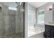 Bathroom featuring soaking tub with shower and glass door, vanity, and natural lighting at 840 E Baylor Ln, Chandler, AZ 85225