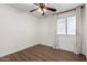 Neutral bedroom with ceiling fan, hardwood floors, and natural light from the window at 840 E Baylor Ln, Chandler, AZ 85225