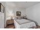 Bedroom with wood floor, white walls, a queen-sized bed with beige and white bedding and two side tables with lamps at 9450 E Becker Ln # 1046, Scottsdale, AZ 85260
