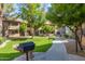 Well-maintained community area with barbecue grill and a pathway surrounded by green lawn at 9450 E Becker Ln # 1046, Scottsdale, AZ 85260