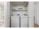 Laundry room with white washer and dryer, shelf above, and white door with a bathroom at 9450 E Becker Ln # 1046, Scottsdale, AZ 85260