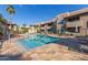 Community pool with lounge chairs, palm trees, and lush landscaping with multiple buildings in the background at 9450 E Becker Ln # 1046, Scottsdale, AZ 85260
