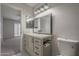 Bathroom with vanity and sink, toilet, and doorway leading to carpeted bedroom with shutters at 10101 N 91St Ave # 111, Peoria, AZ 85345