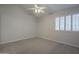 A well-lit carpeted bedroom with shuttered windows and a ceiling fan at 10101 N 91St Ave # 111, Peoria, AZ 85345