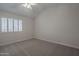 Carpeted bedroom featuring a ceiling fan and bright, shuttered window at 10101 N 91St Ave # 111, Peoria, AZ 85345