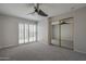 Bright bedroom featuring plantation shutters, ceiling fan, and mirrored closet at 10101 N 91St Ave # 111, Peoria, AZ 85345
