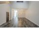 Open living room with gray tone wood flooring and a decorative wooden barn door at 10101 N 91St Ave # 111, Peoria, AZ 85345