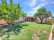 Expansive backyard with mature trees providing shade, a covered patio, and additional storage shed at 13810 N 39Th Ave, Phoenix, AZ 85053