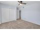 This bright bedroom offers a ceiling fan, sliding closet doors, and neutral carpet at 13810 N 39Th Ave, Phoenix, AZ 85053