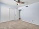 Bright bedroom offers a ceiling fan, sliding closet doors, and neutral carpet at 13810 N 39Th Ave, Phoenix, AZ 85053