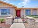 Close-up of a charming home's entrance with a red front door, brick accents, and a well-kept garden at 13810 N 39Th Ave, Phoenix, AZ 85053