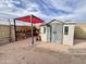 Backyard shed with a red shade sail and potted plants under a clear blue sky at 14345 N 101St St, Scottsdale, AZ 85260