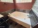 Bathroom with a bright soaking tub and dark tile at 14345 N 101St St, Scottsdale, AZ 85260