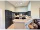 Modern kitchen with sleek, dark cabinetry and stainless steel appliances at 14345 N 101St St, Scottsdale, AZ 85260
