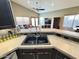 View of the kitchen sink and countertop leading to the living room with a comfortable leather sectional at 14345 N 101St St, Scottsdale, AZ 85260