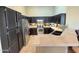 Modern kitchen with black cabinetry, stainless steel appliances, and tan countertops at 14345 N 101St St, Scottsdale, AZ 85260
