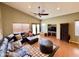 Spacious living room with vaulted ceiling, ceiling fan, brown leather sofa, and view to outside at 14345 N 101St St, Scottsdale, AZ 85260
