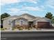Charming single-story home with stone accents, a neutral palette, and a well-manicured front yard at 15952 W El Cortez Pl, Surprise, AZ 85387