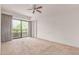 Spacious bedroom with neutral carpet, balcony access, and a ceiling fan at 16 W Encanto Blvd # 26, Phoenix, AZ 85004