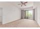 Bright bedroom featuring neutral carpet, a ceiling fan, and a door to the balcony at 16 W Encanto Blvd # 26, Phoenix, AZ 85004